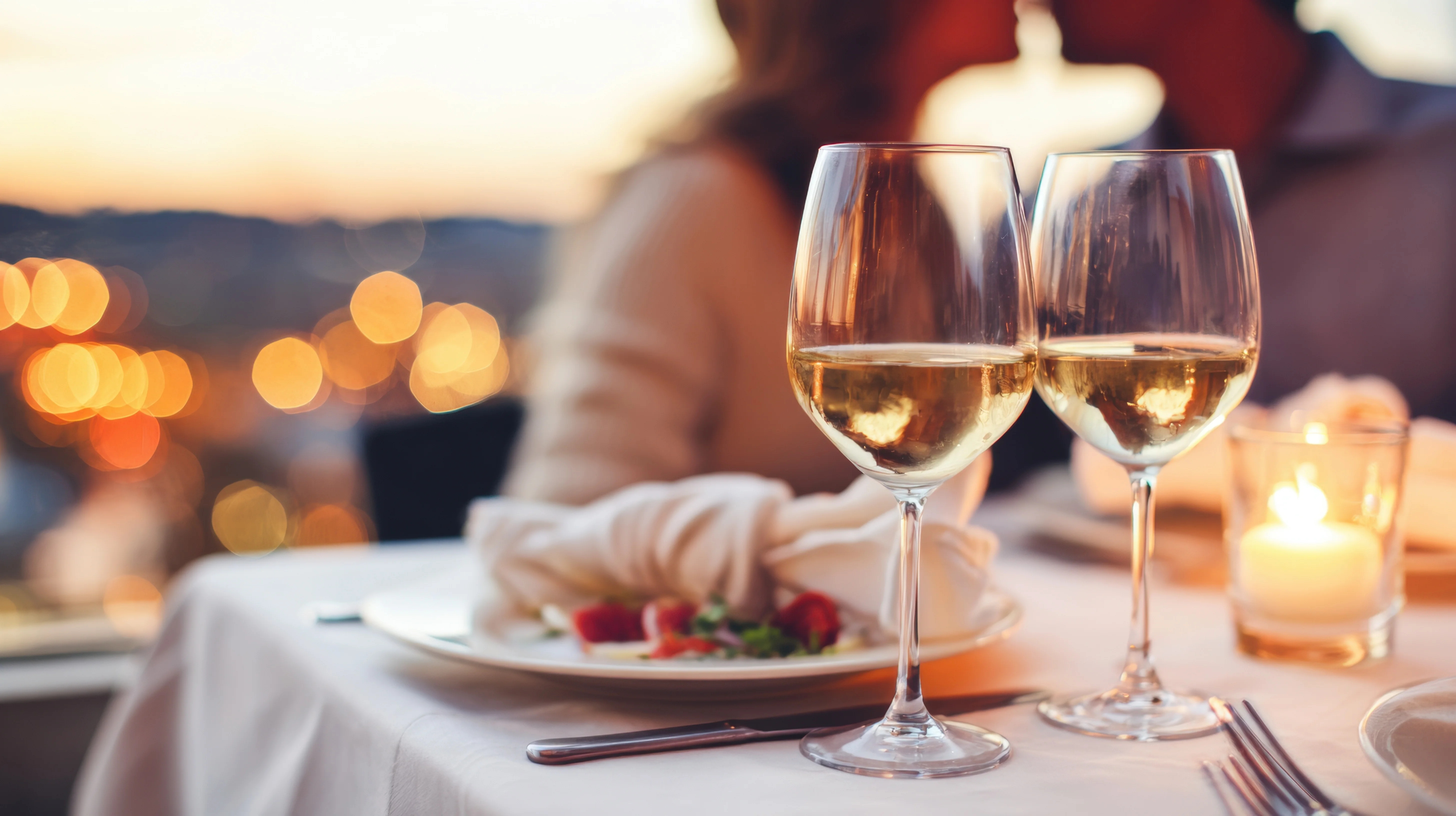 Romantic dinner setting with white wine and candlelight