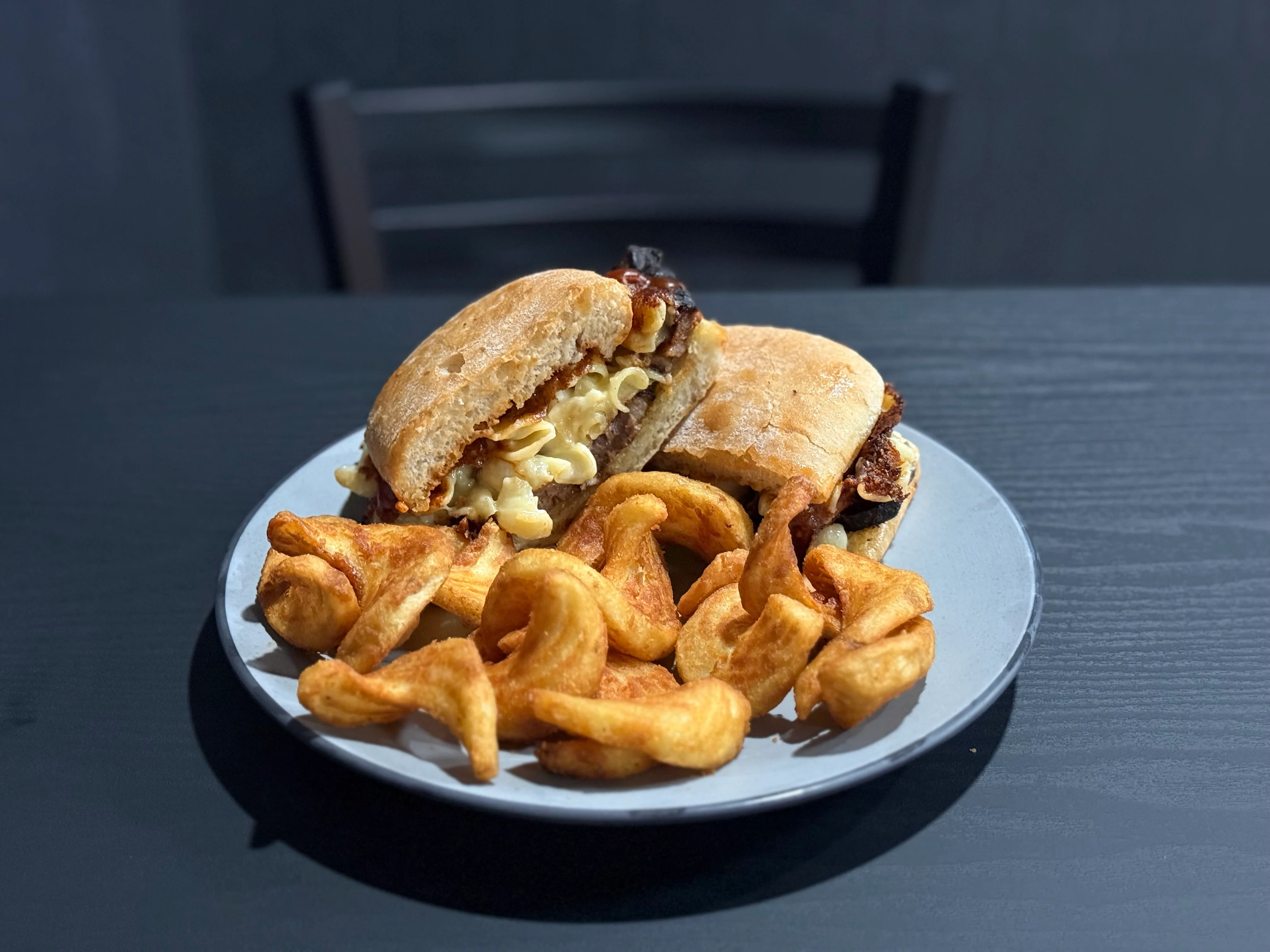 Hearty cheeseburger with curly fries on a plate