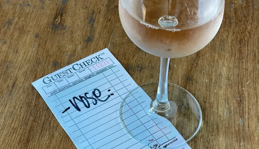 Glass of rosé wine on a guest check