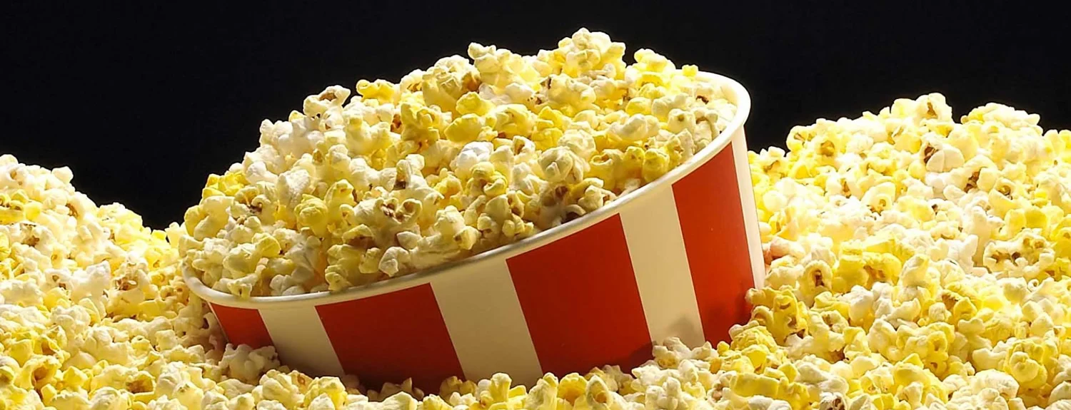 Freshly popped popcorn in a classic red and white striped bucket