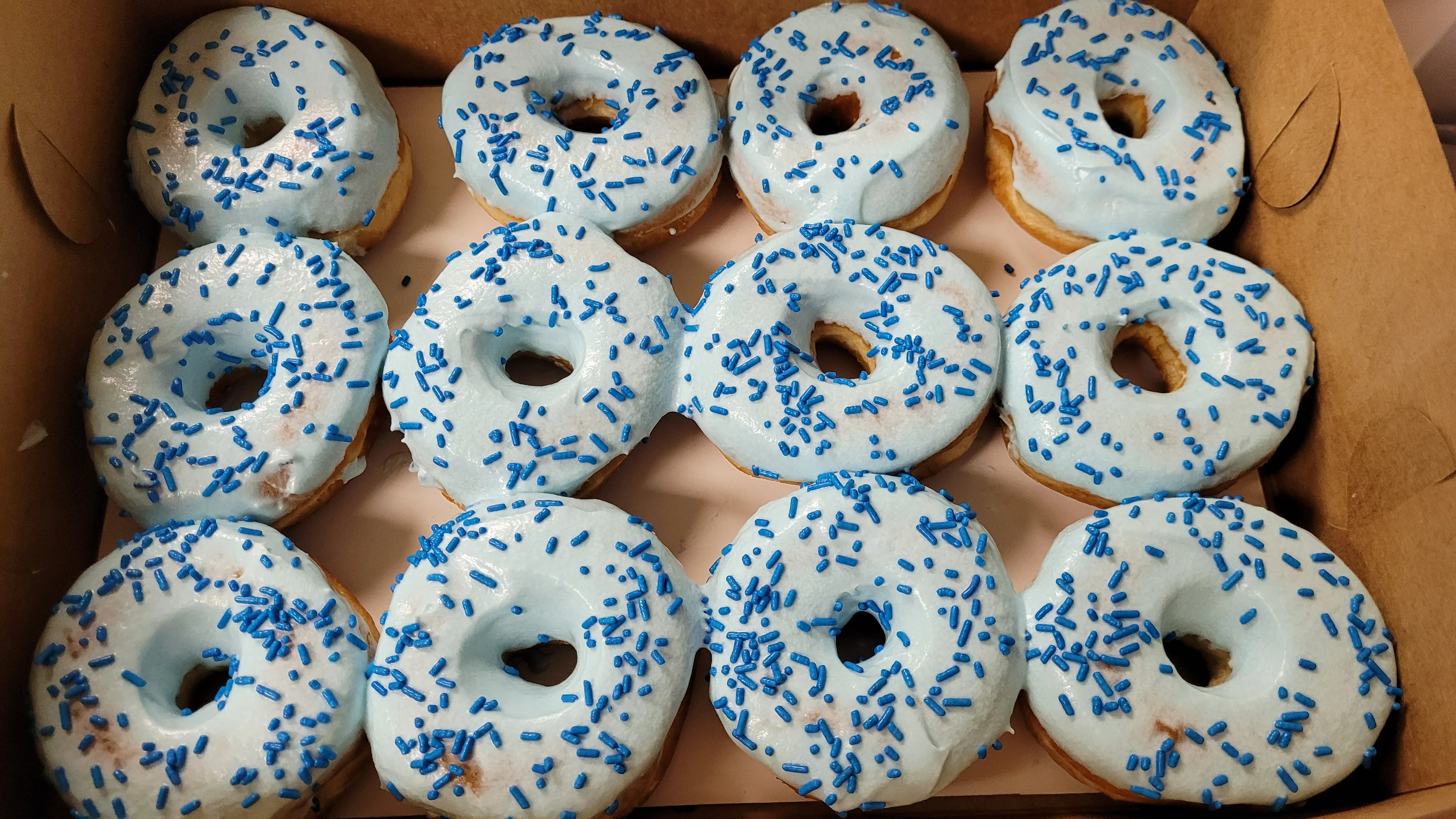 Frosted blue donuts with sprinkles in a box