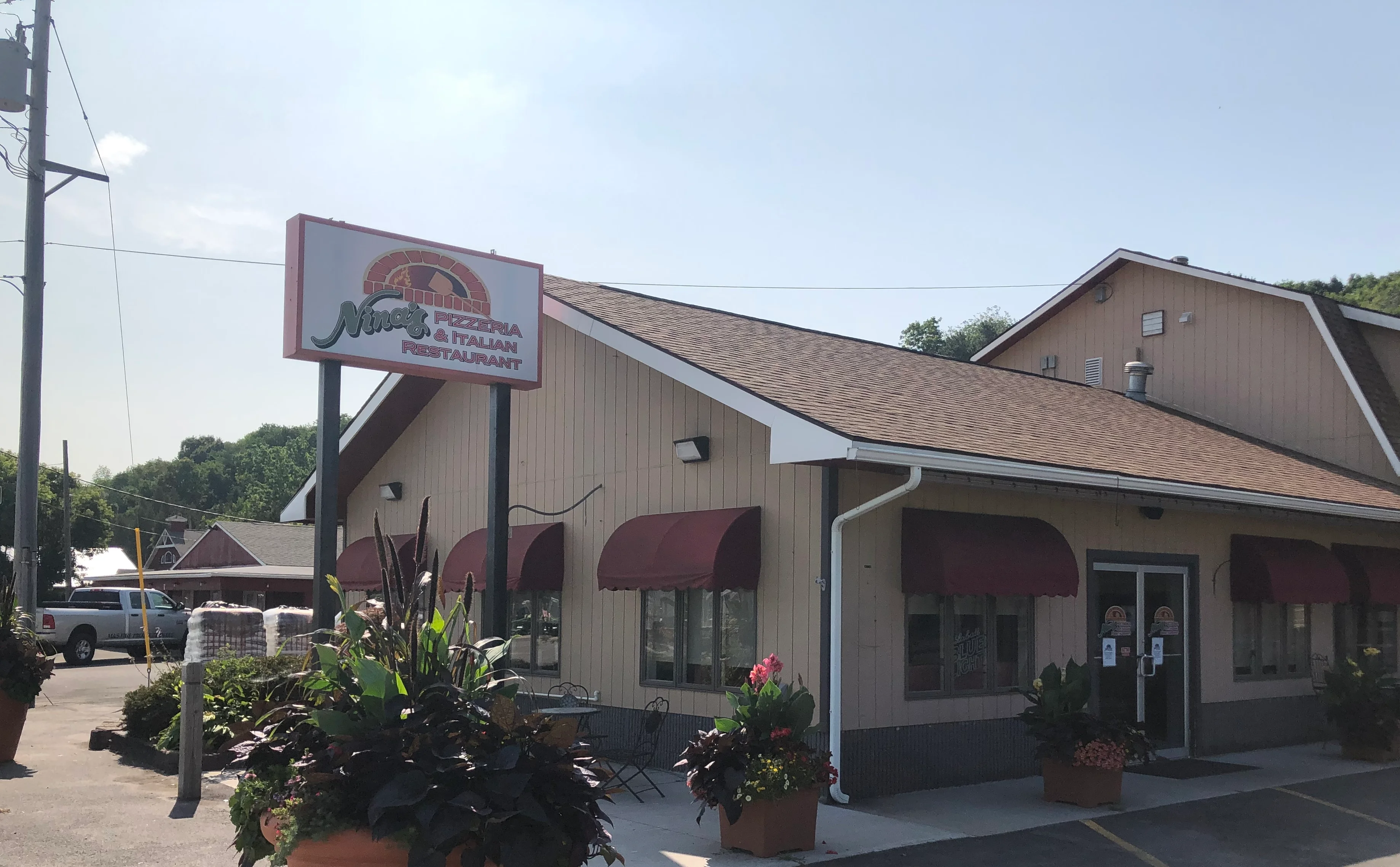 Exterior view of Nina's Pizzeria and Italian Restaurant at 800 E Genesee St, Chittenango, NY with red awnings and restaurant sign.