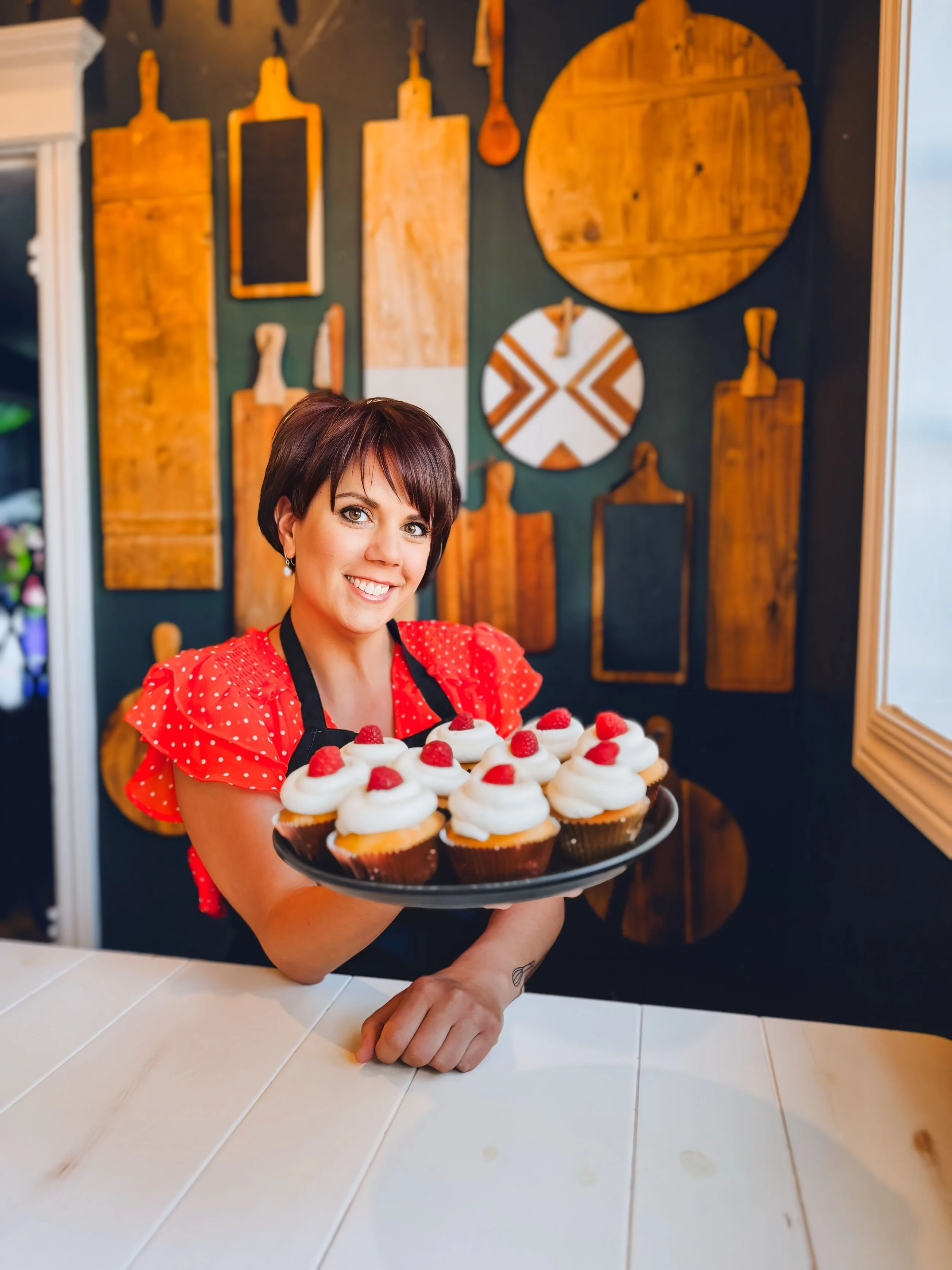 Delicious cupcakes topped with cream and raspberries