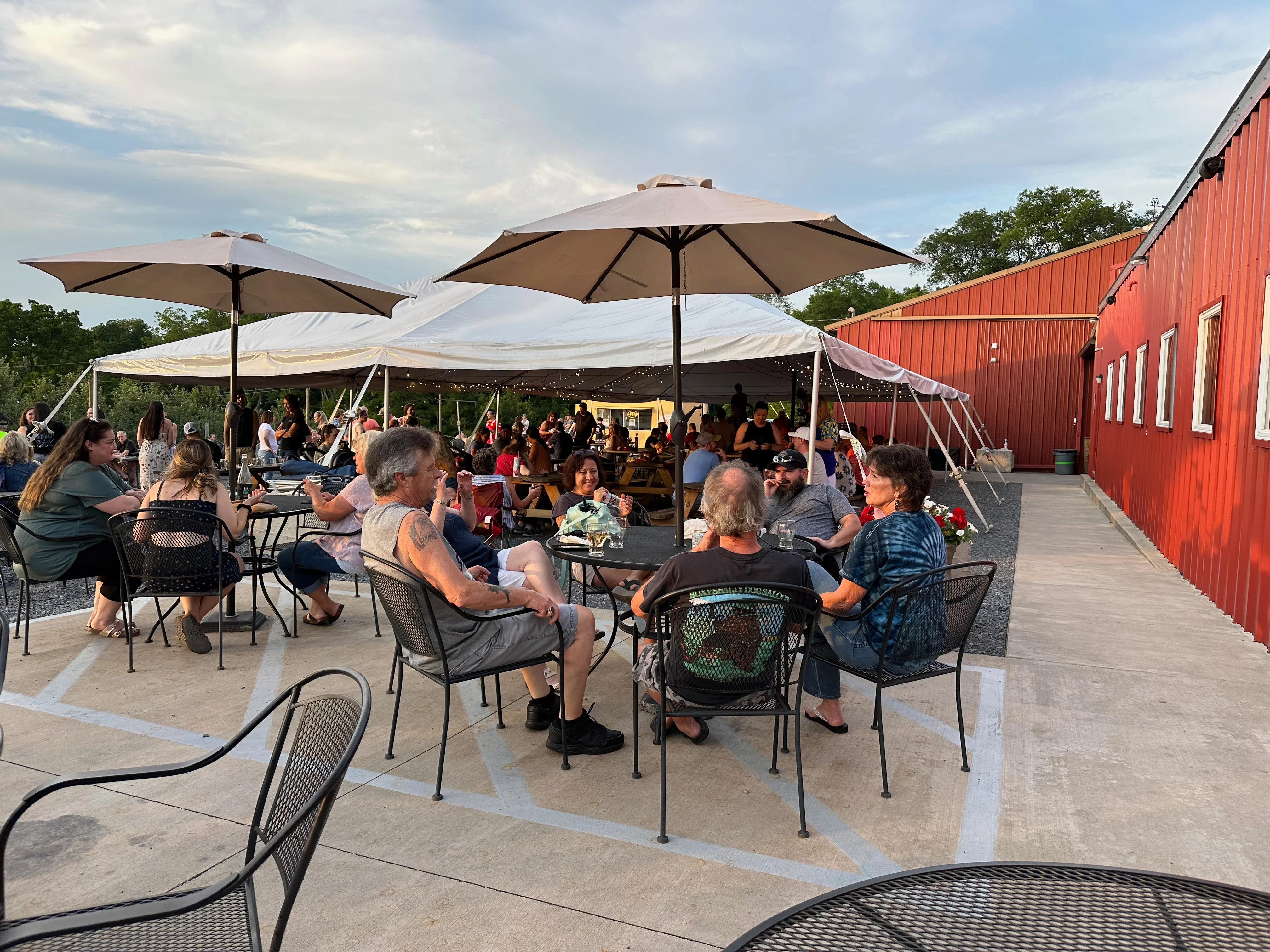 Outdoor dining area with guests under a large tent