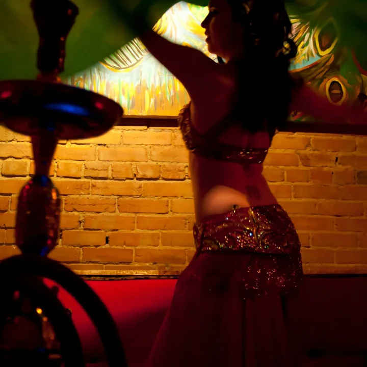 Belly dancer performing in a vibrant restaurant setting