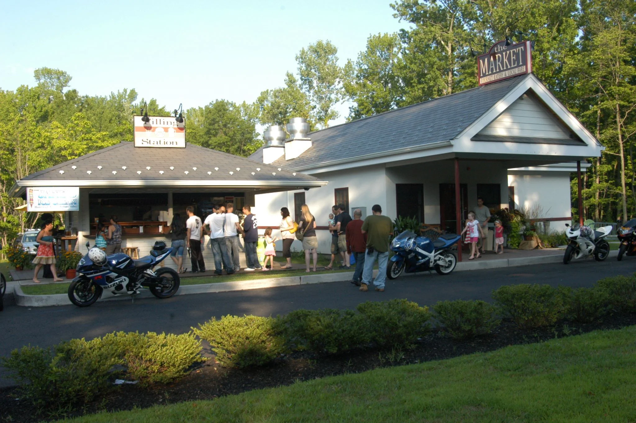 Outdoor dining area of a restaurant with people waiting in line