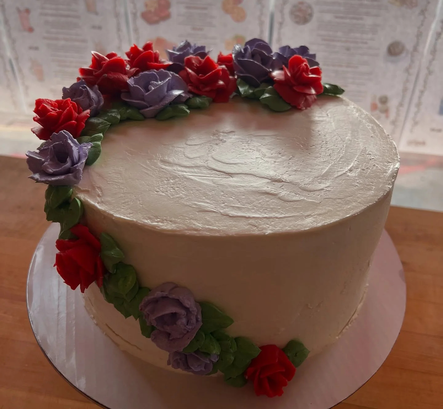 Beautifully decorated floral cake with red and purple icing roses