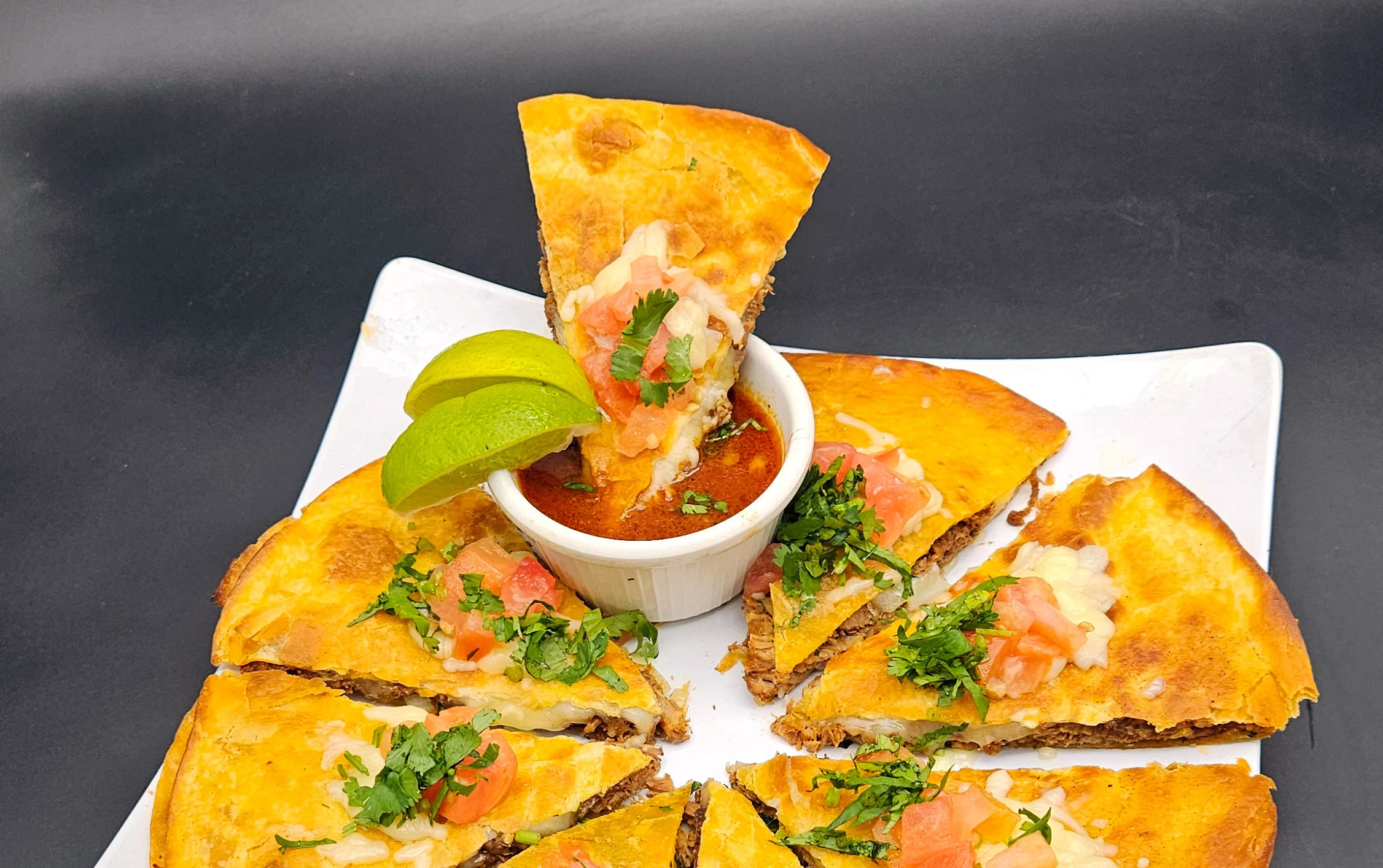 Delicious Mexican quesadilla served with salsa and fresh toppings