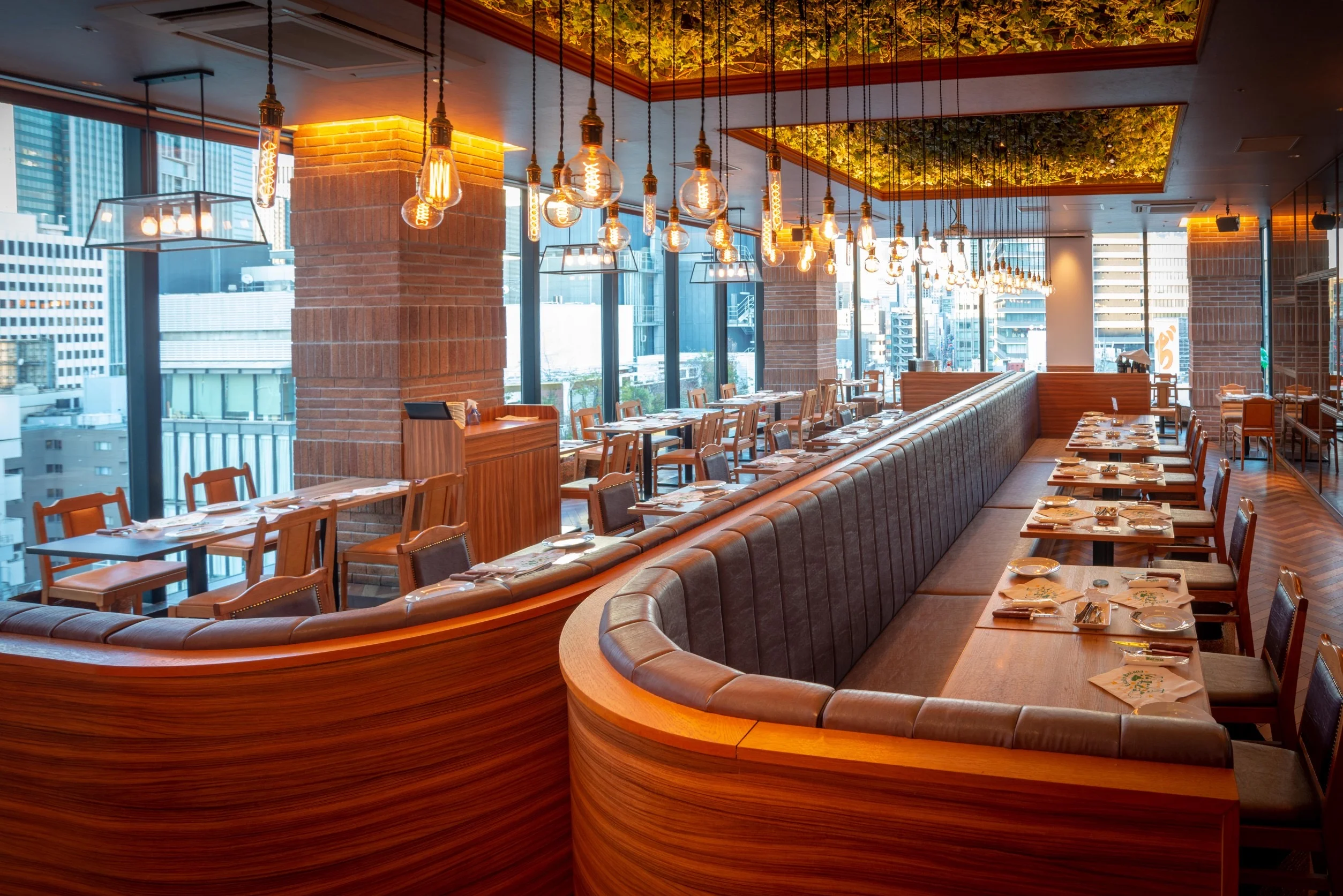 Modern restaurant interior with warm lighting and city views