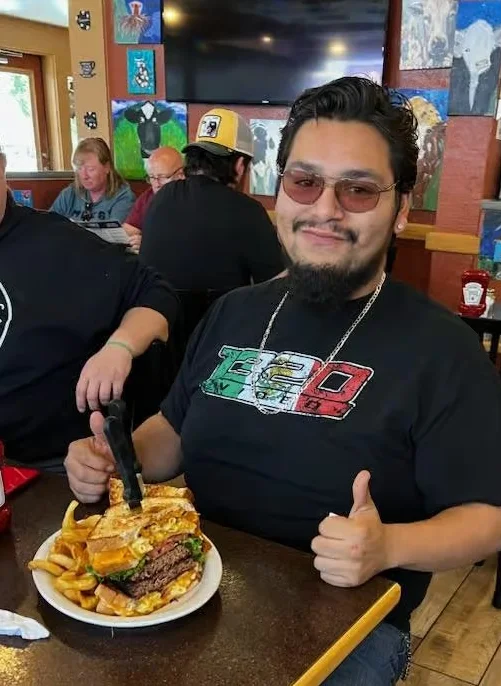 Giant cheeseburger with fries in a casual restaurant setting