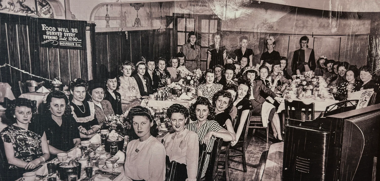 Vintage dining scene with women at a long table
