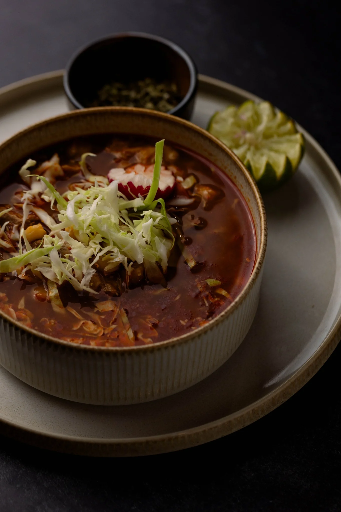 Bowl of Mexican pozole topped with cabbage and radish