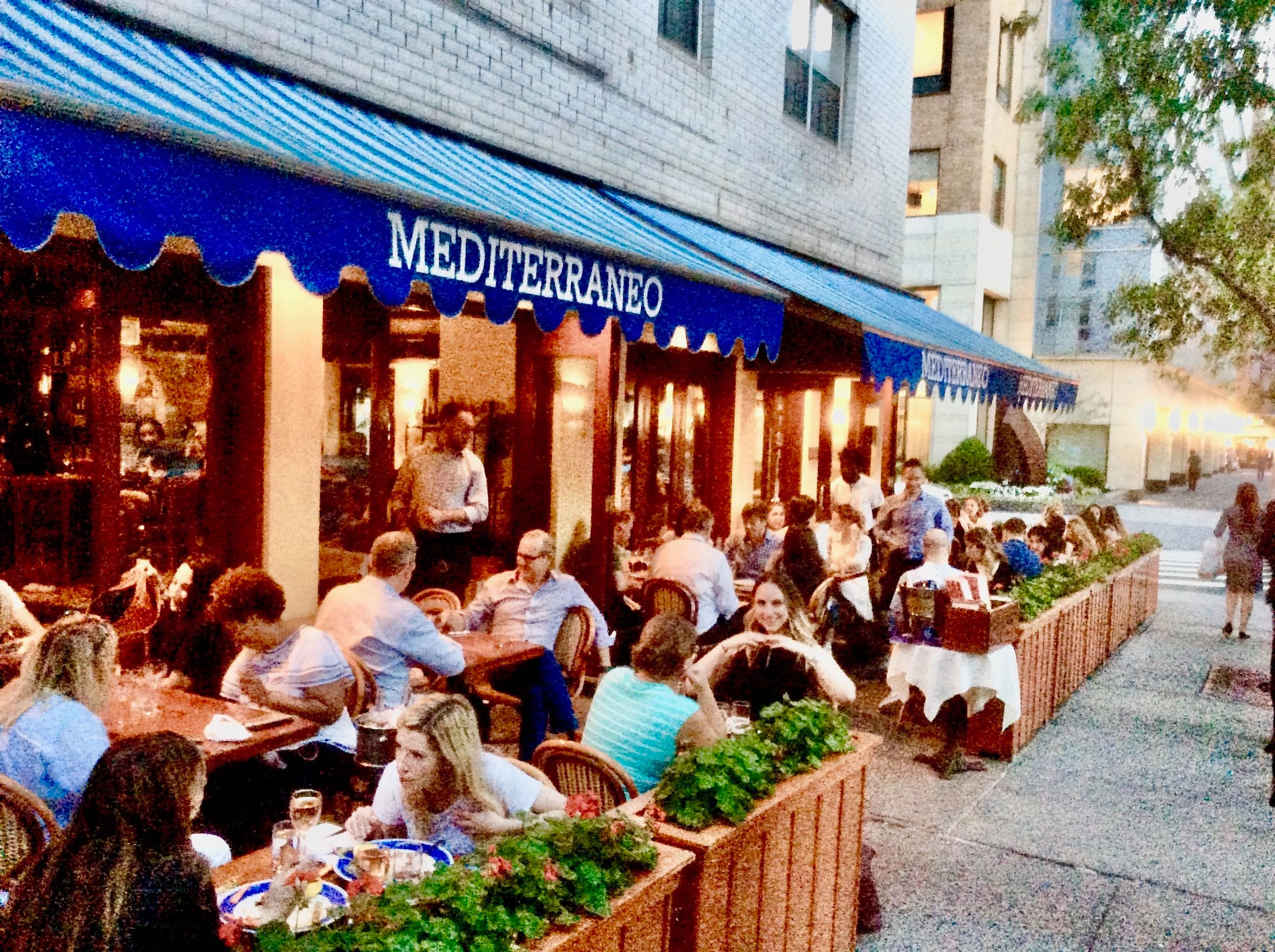 Outdoor dining at a Mediterranean restaurant with vibrant atmosphere