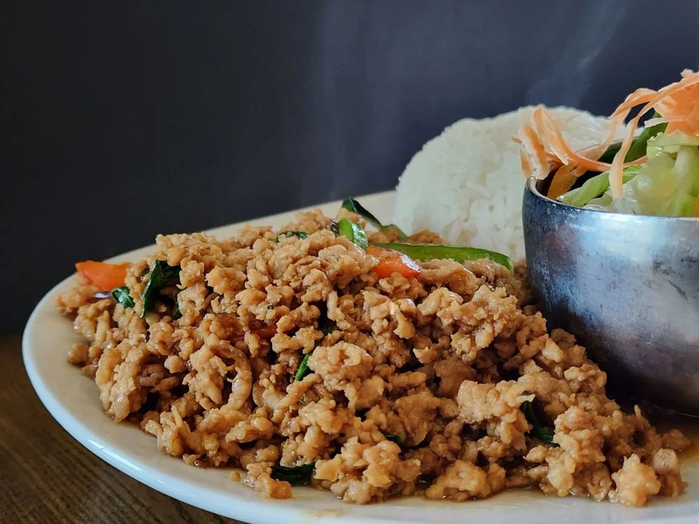 Thai basil chicken served with rice and fresh vegetables