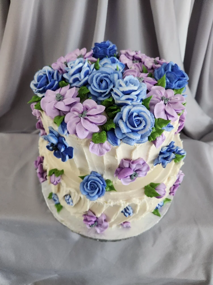 Elegant floral cake decorated with blue and purple buttercream roses