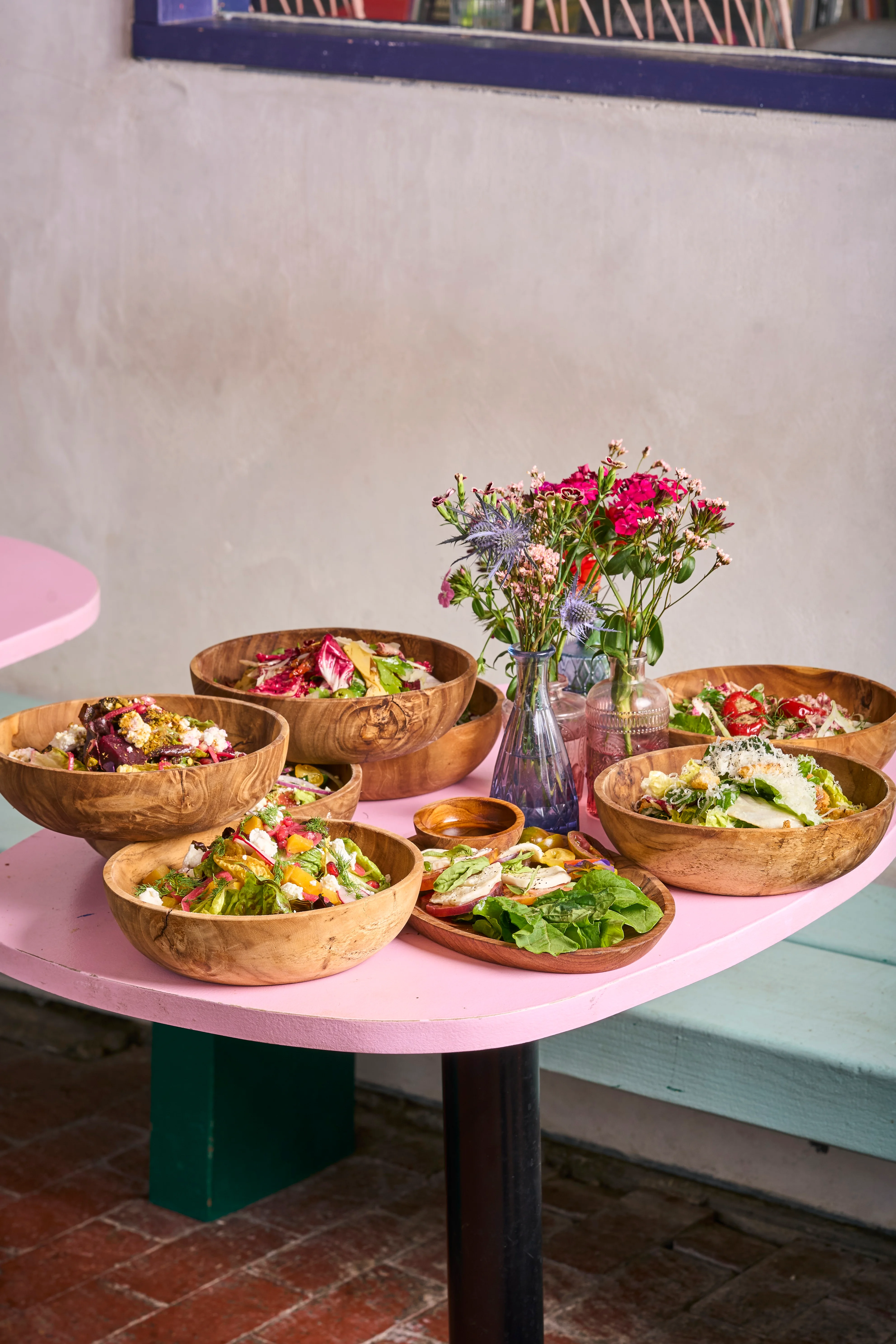 Colorful Mediterranean salad bowls on a pink table