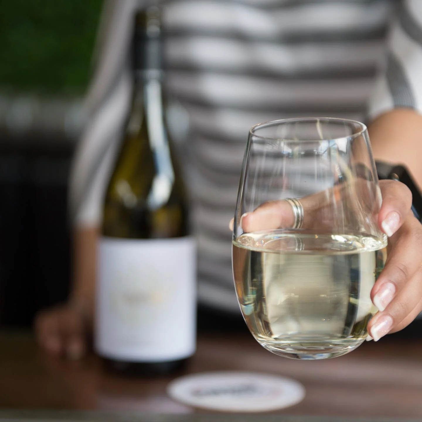 Glass of white wine being served at a bar
