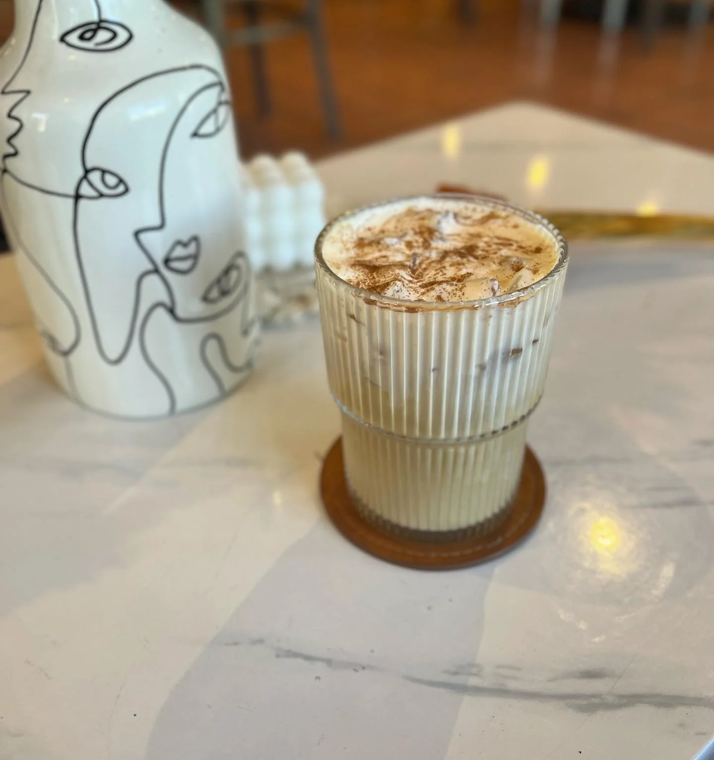 Iced coffee topped with whipped cream and cocoa powder