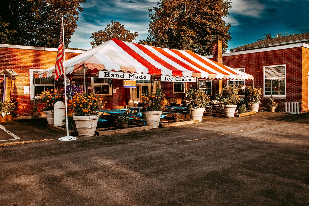Charming ice cream shop with striped awning and flower pots