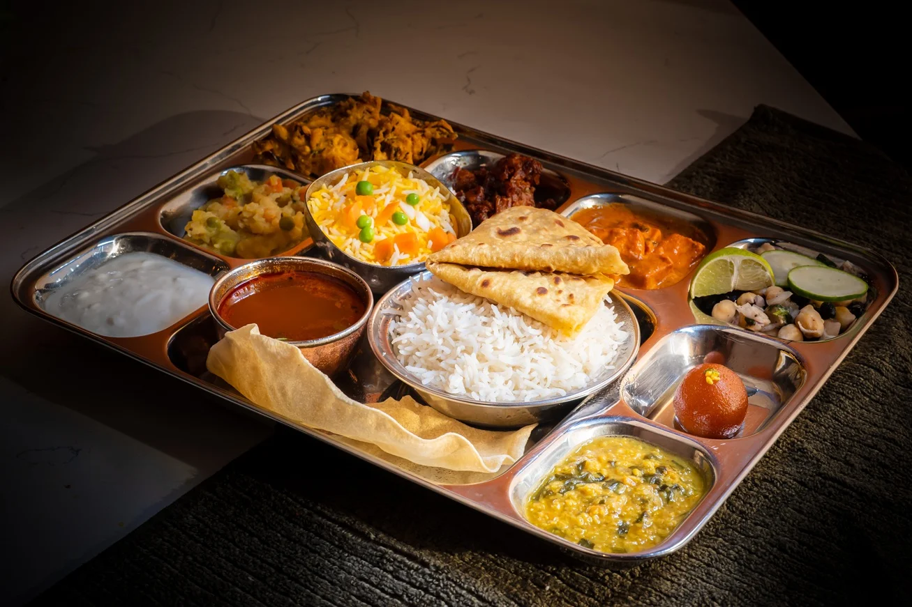 Traditional Indian thali with rice, roti, and various curries