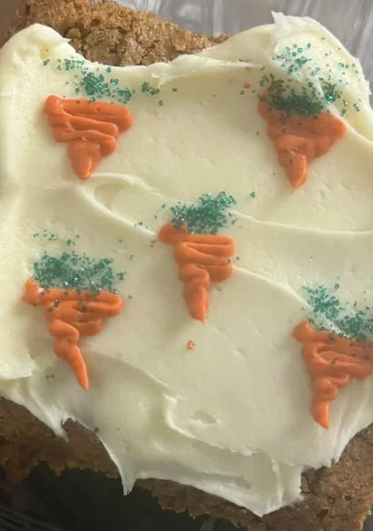 Carrot cake slice with cream cheese frosting and decorative icing
