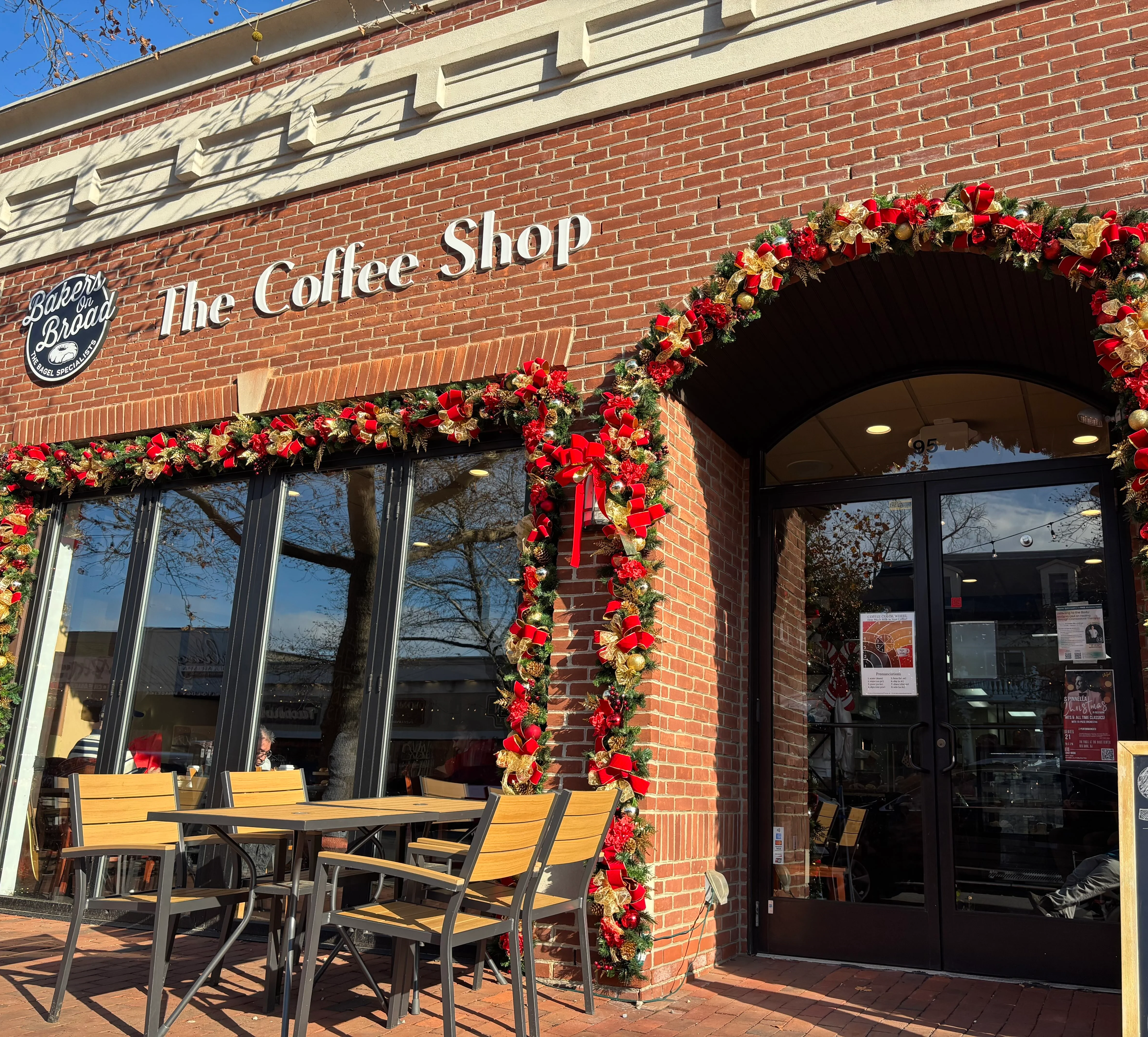 Festively decorated coffee shop entrance with holiday wreaths