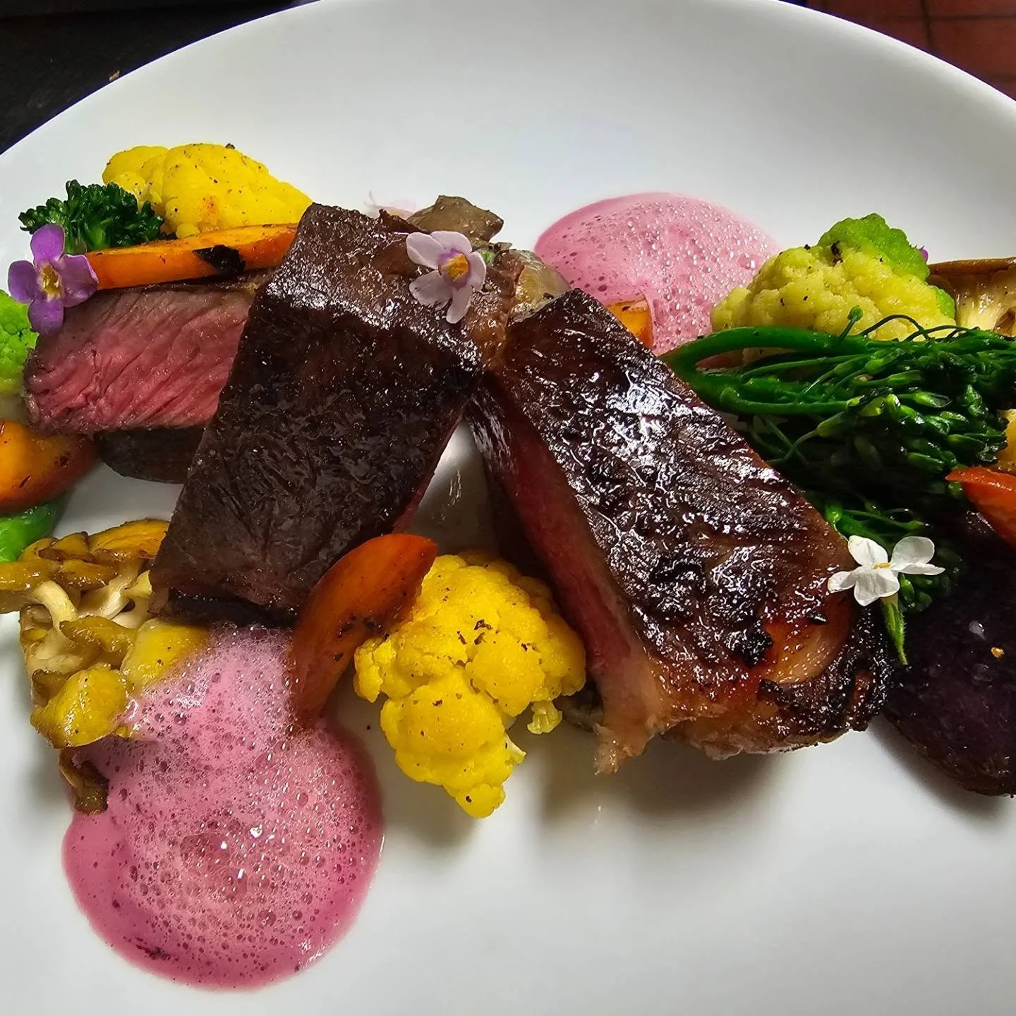 Grilled NY strip steak with peach, cauliflower, and pomegranate foam