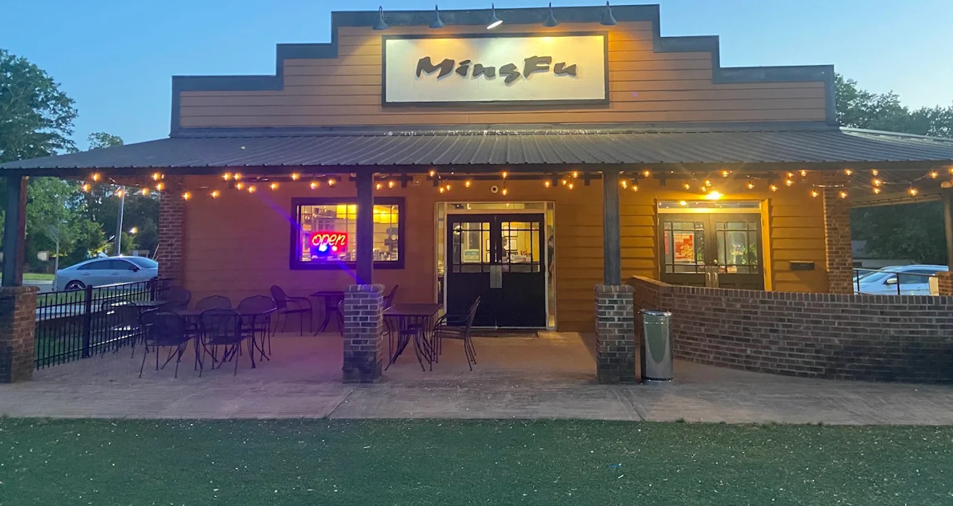 Charming restaurant exterior with warm lighting and outdoor seating