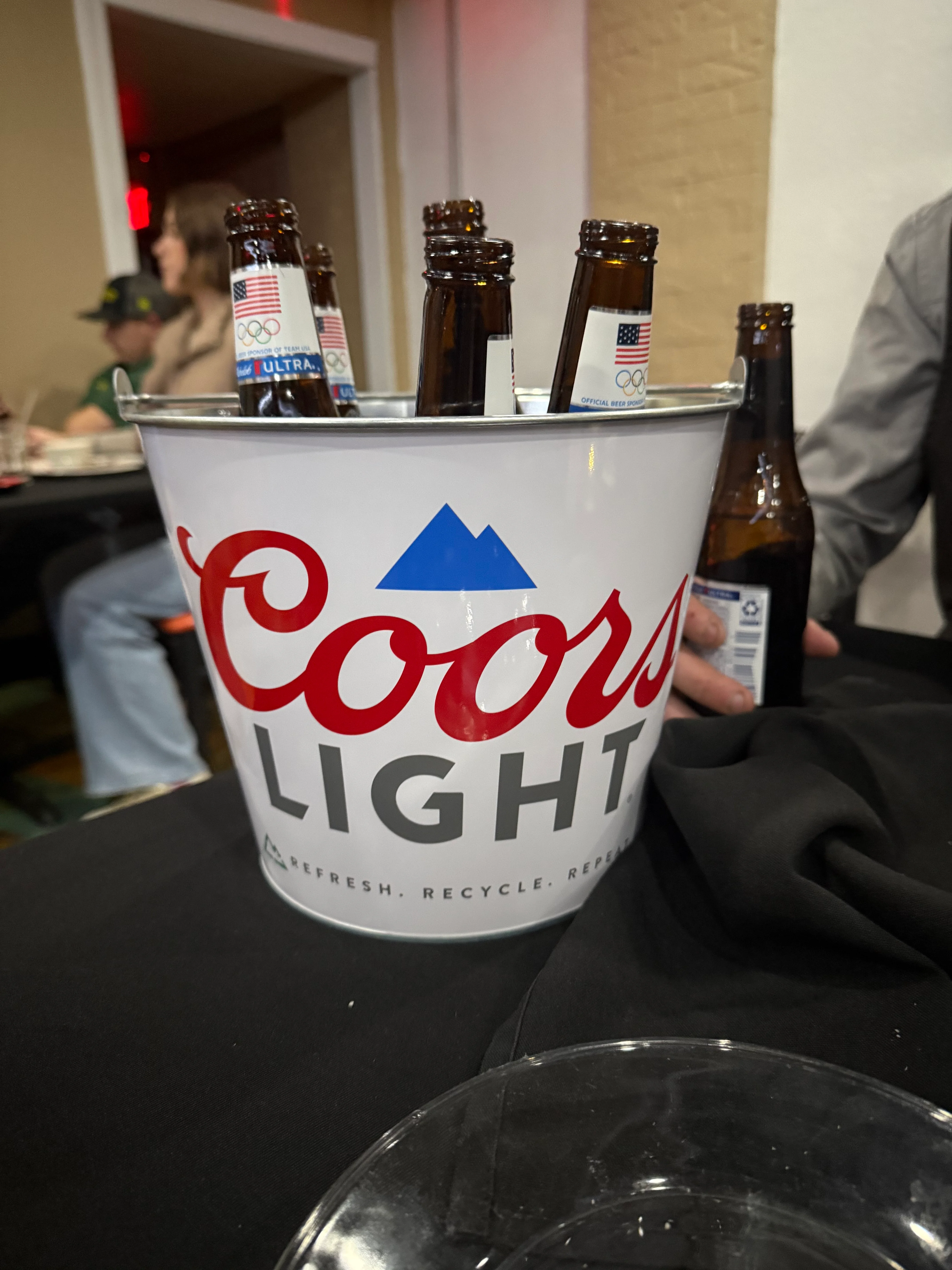 Ice bucket filled with Coors Light beer bottles at a restaurant table