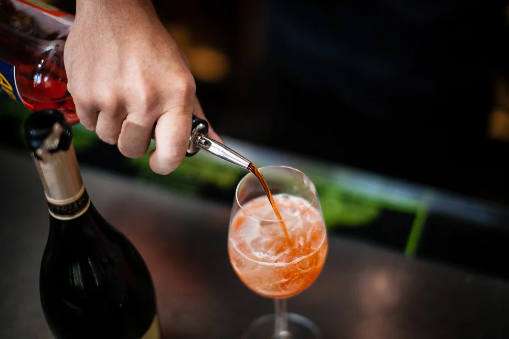 Bartender pouring a cocktail into a glass at a stylish bar