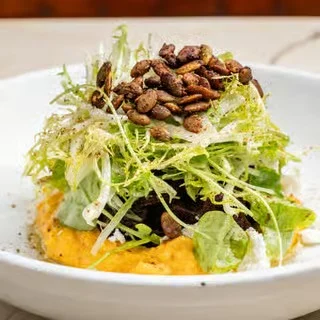 Vibrant salad with roasted pumpkin puree and crunchy seeds