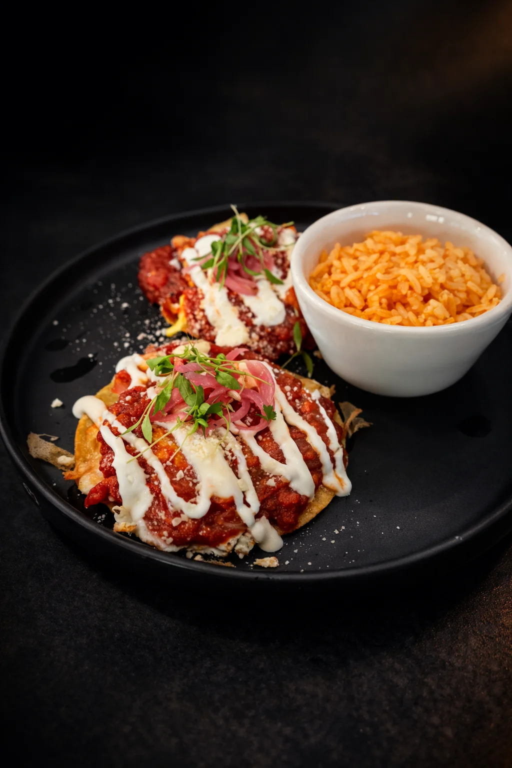 Mexican enchiladas topped with sauce and crema