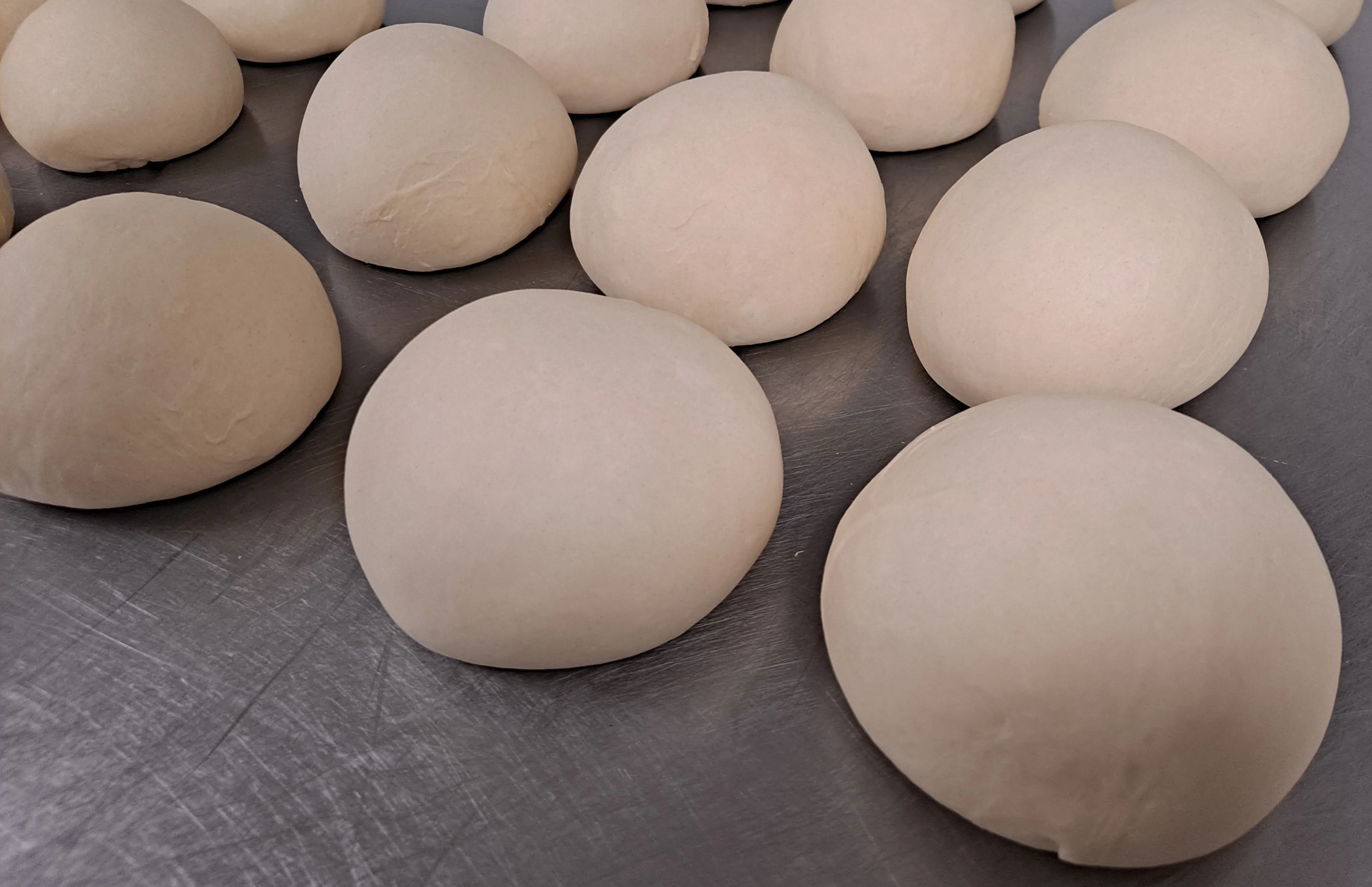 Freshly kneaded pizza dough balls ready for baking