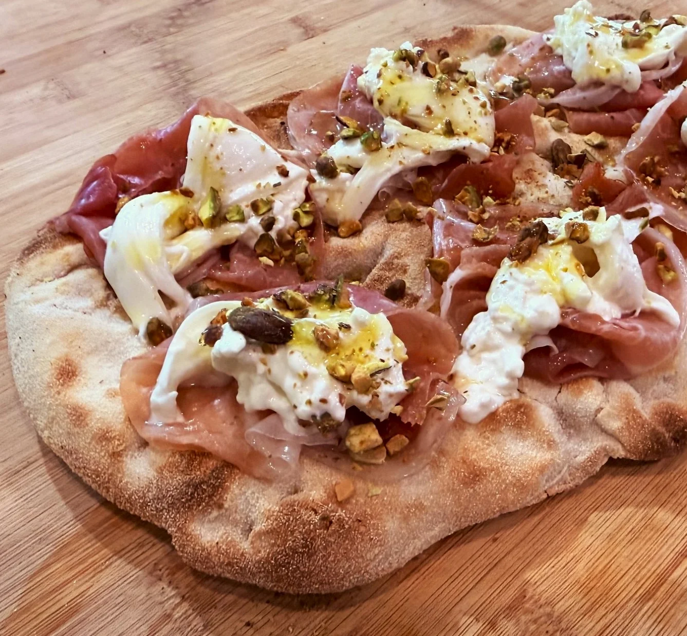 La Pistacchiosa pinsa Romana topped with prosciutto, burrata and pistachios at Daje Pinsa Roma Pizza in Orlando.