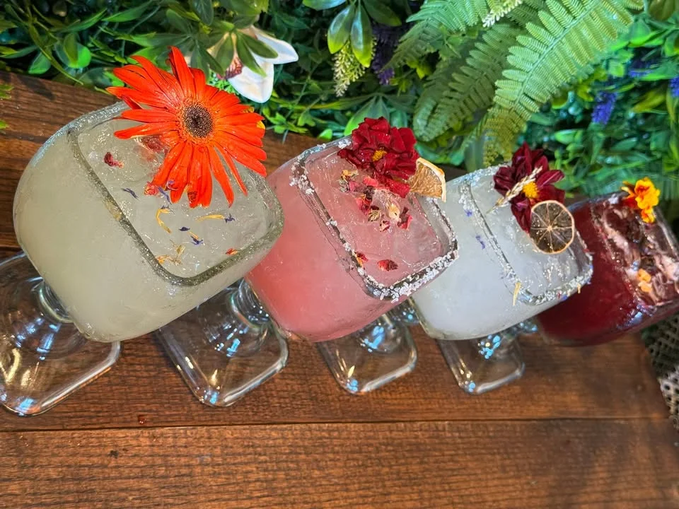 Colorful cocktails garnished with flowers at a vibrant bar