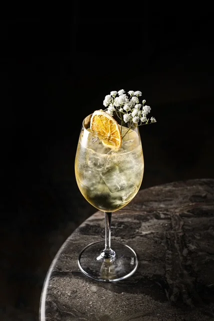 Elegant cocktail garnished with dried orange and flowers