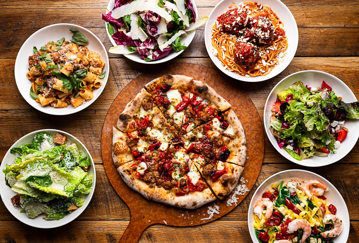 Italian feast featuring pizza, pasta, and fresh salads