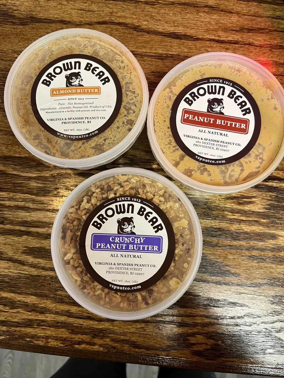Variety of Brown Bear nut butters on a wooden table