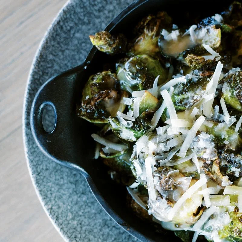 Roasted Brussels sprouts with cheese in a cast iron skillet