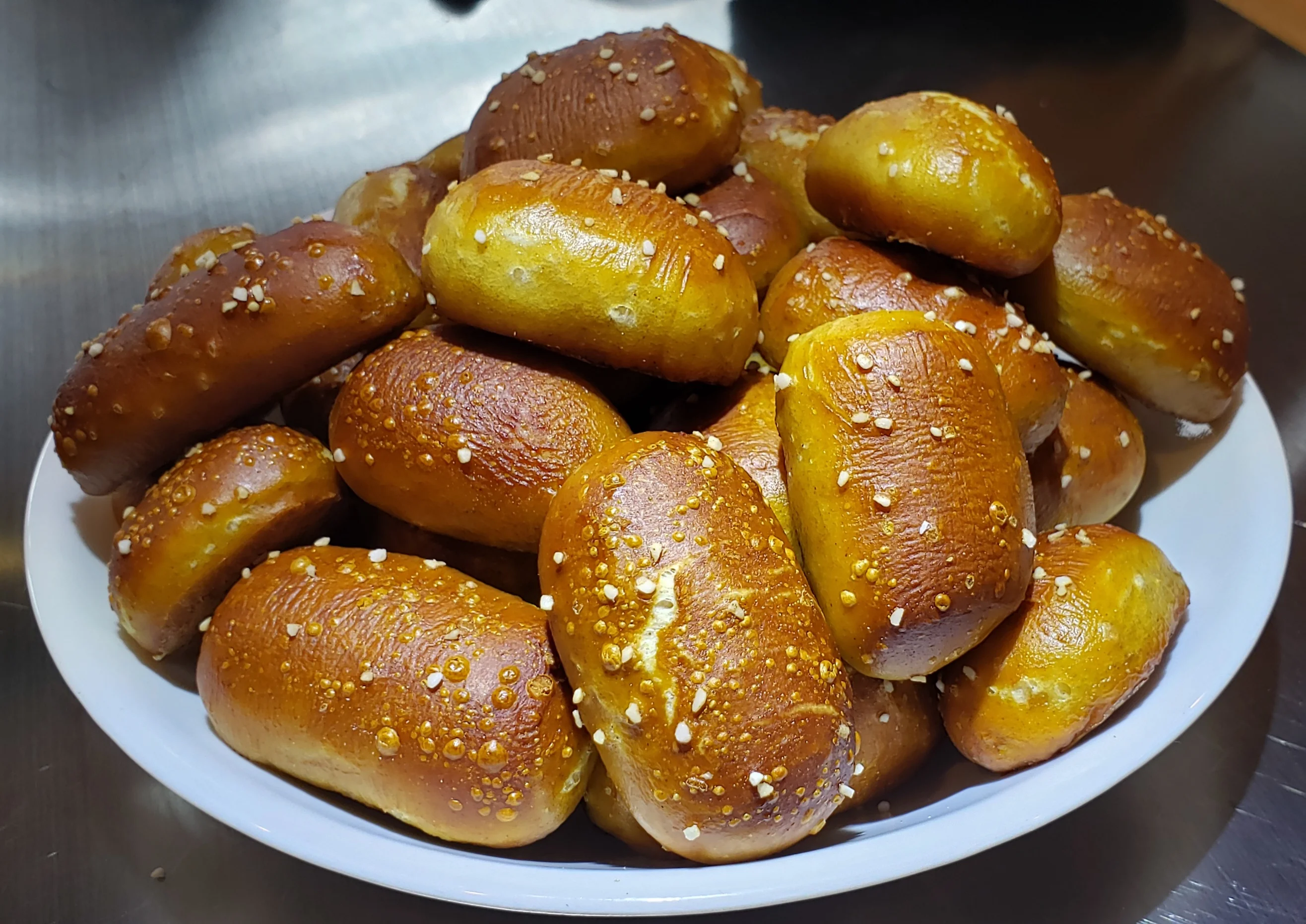 A plate of freshly baked pretzel bites with sesame seeds.