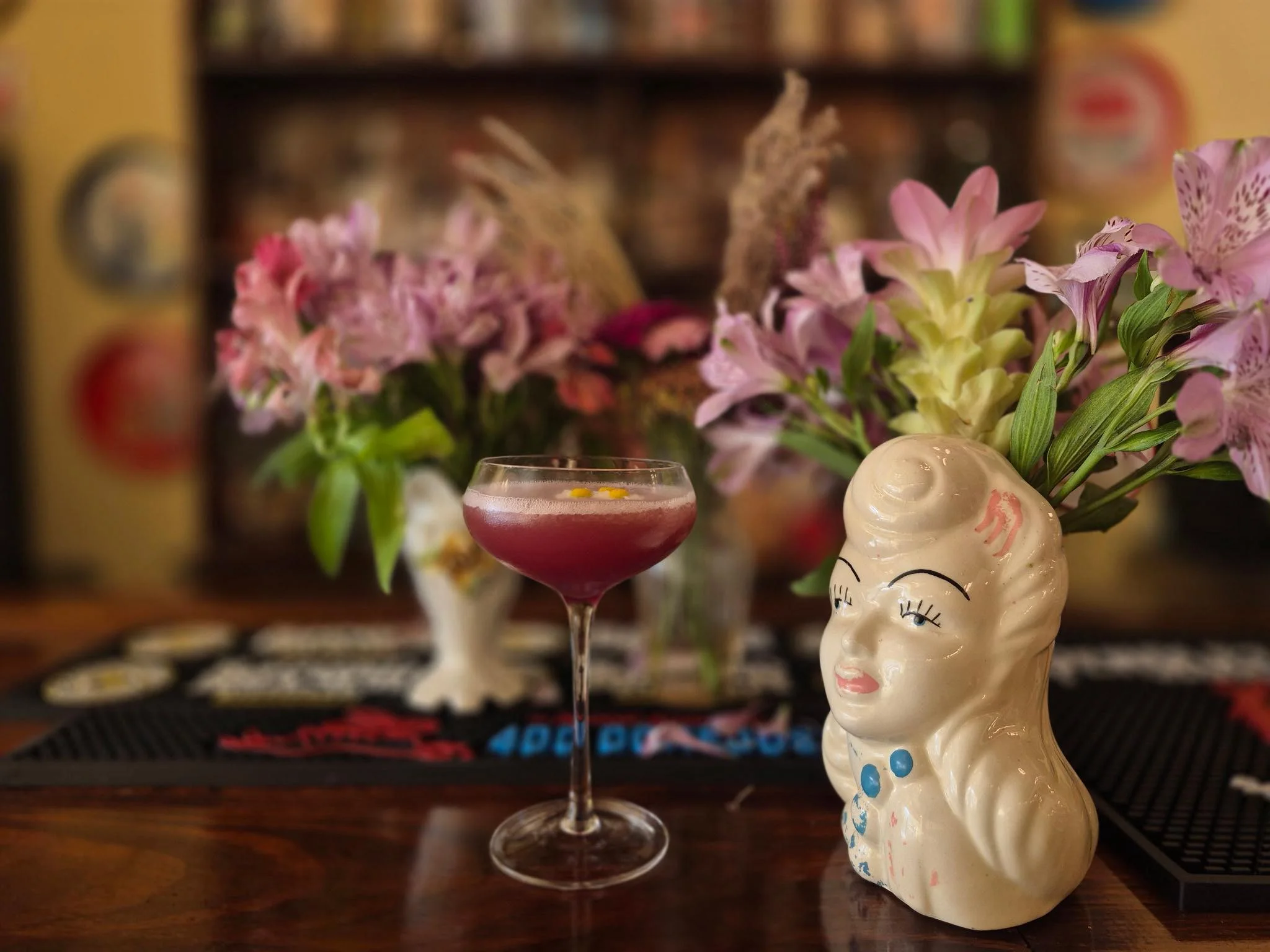 Colorful cocktail served in a vintage glass with floral decor