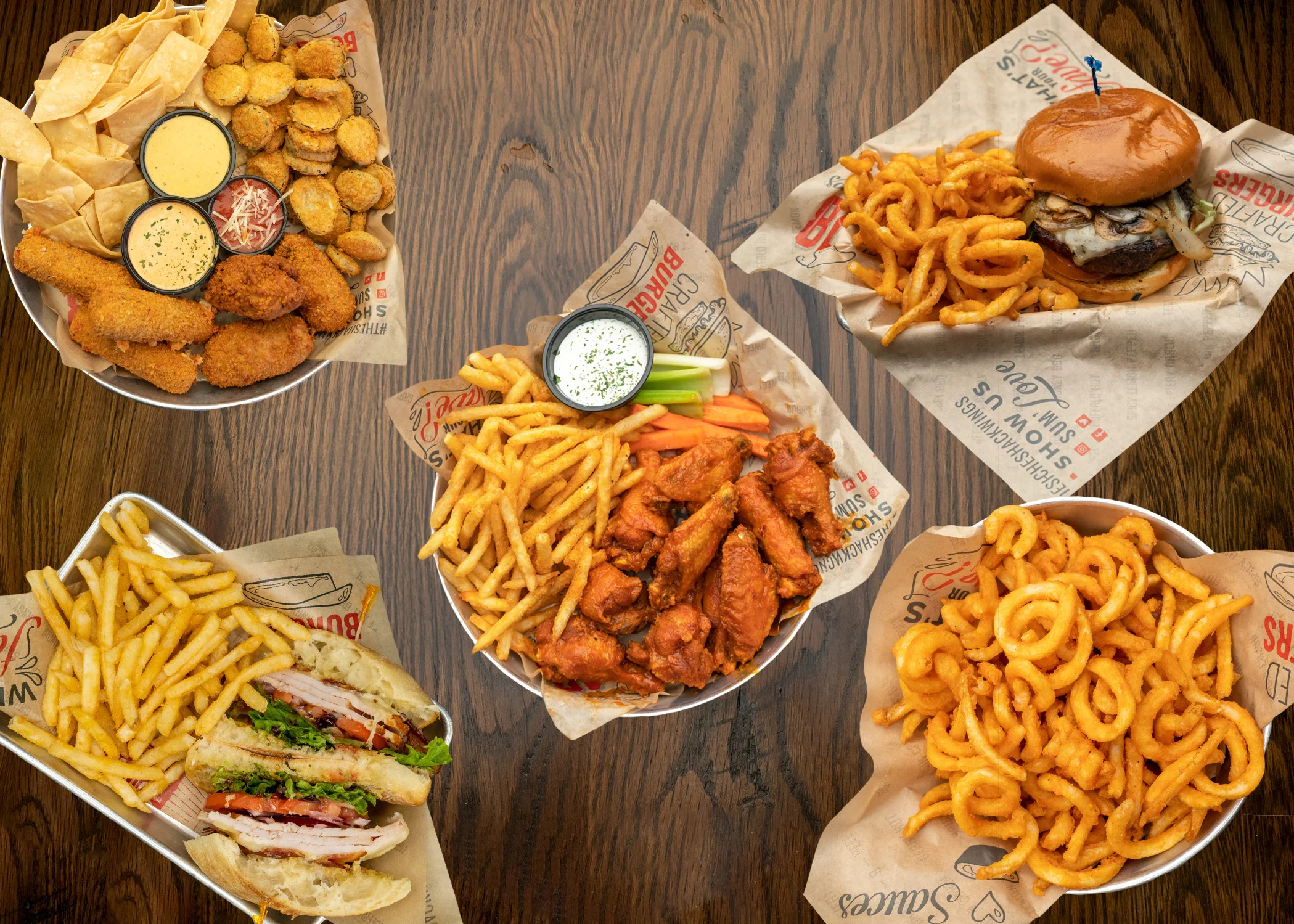 Assorted American comfort food platter with wings and curly fries