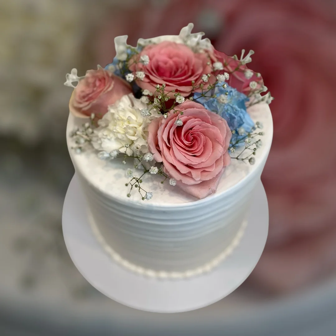 Elegant floral cake with pink roses and delicate decorations