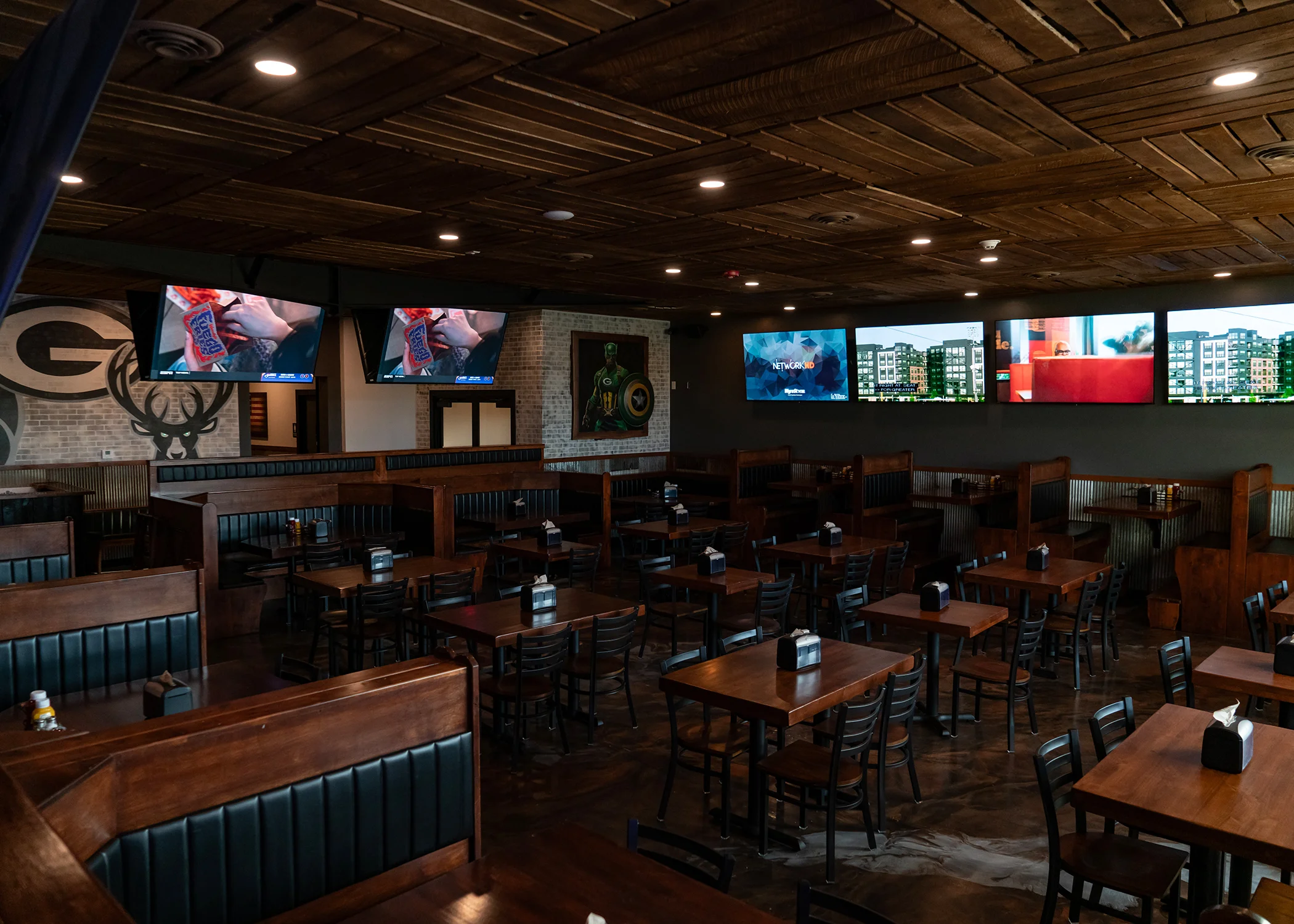 Cozy restaurant interior with wooden booths and multiple TVs