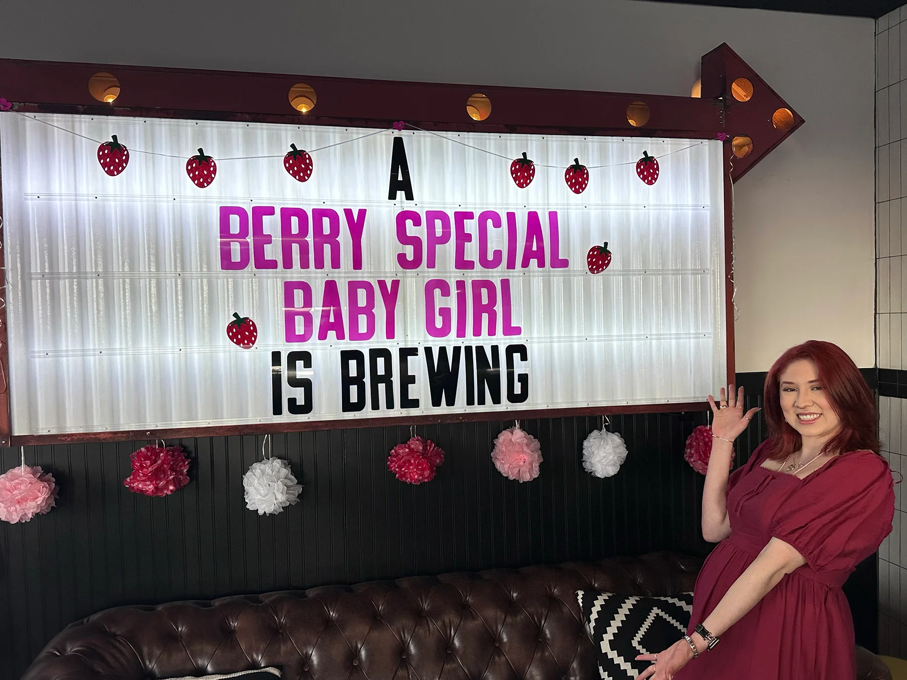 Celebratory sign for a baby girl announcement in a cozy restaurant setting
