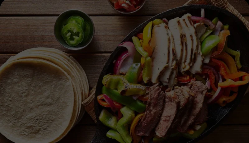 Sizzling fajitas served with tortillas and fresh toppings