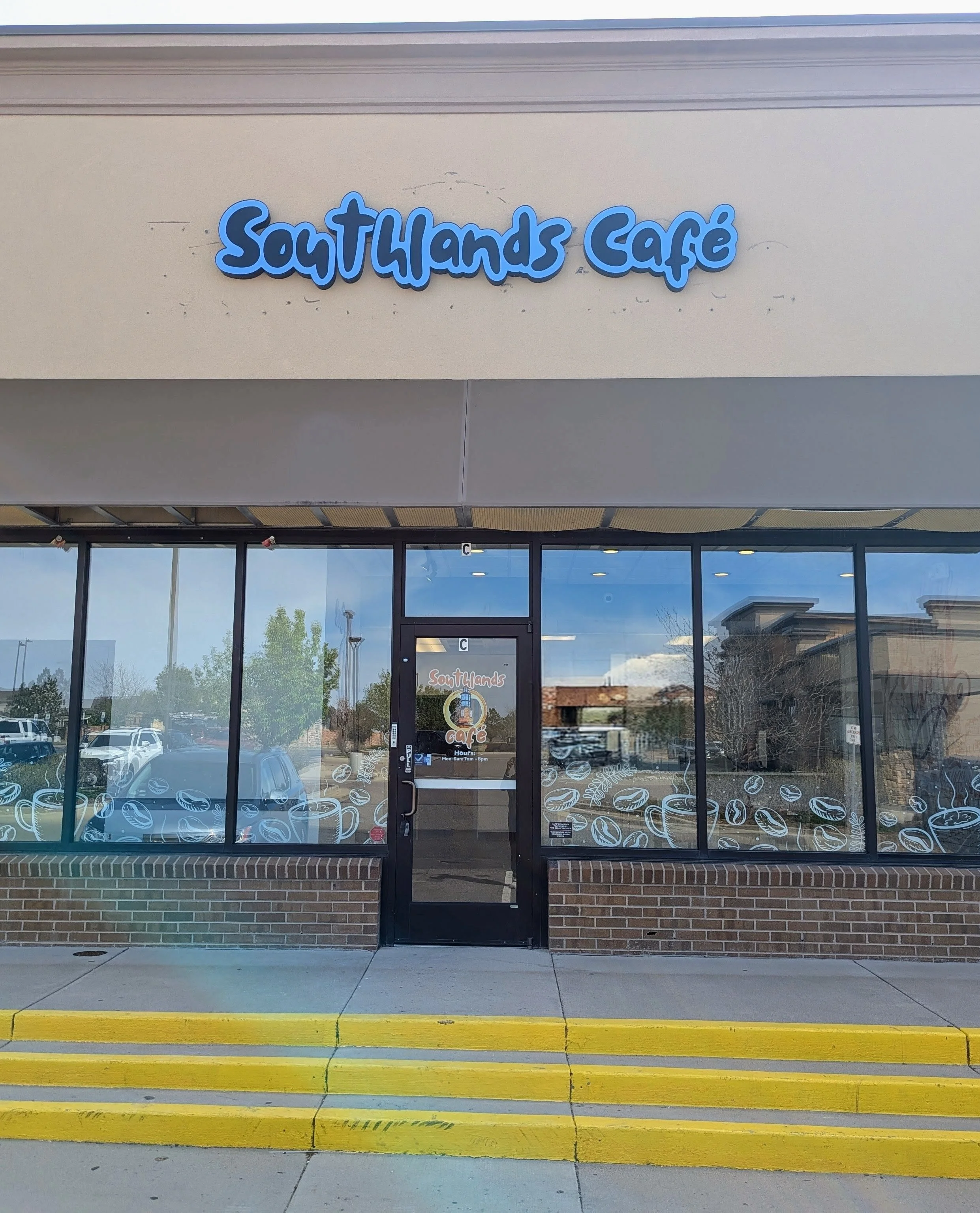 Exterior view of SouthHands Café with large windows and yellow steps.