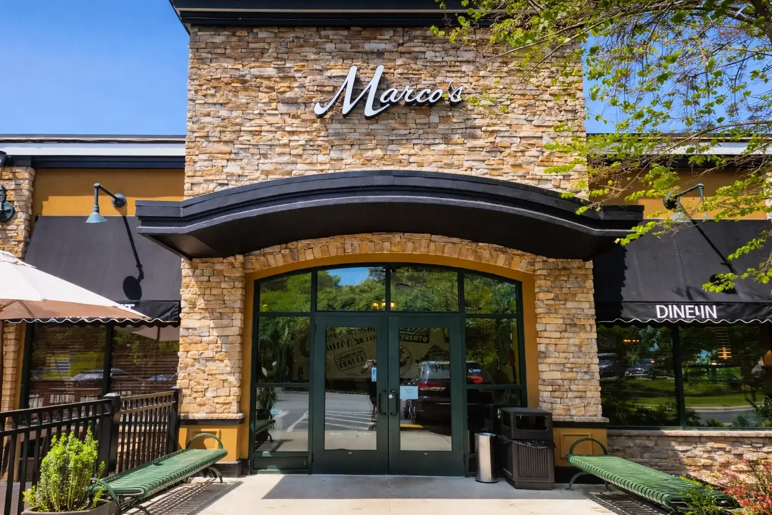 Charming restaurant entrance with stone facade and outdoor seating