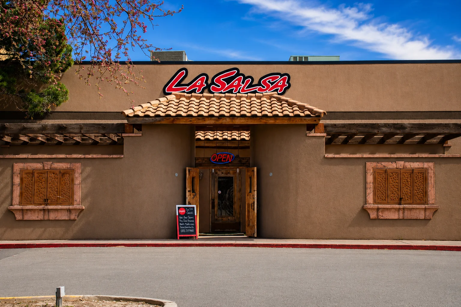 The exterior of a restaurant named La Salsa featuring a rustic design with wooden accents and a terracotta roof. An open sign hangs at the entrance, inviting patrons inside.