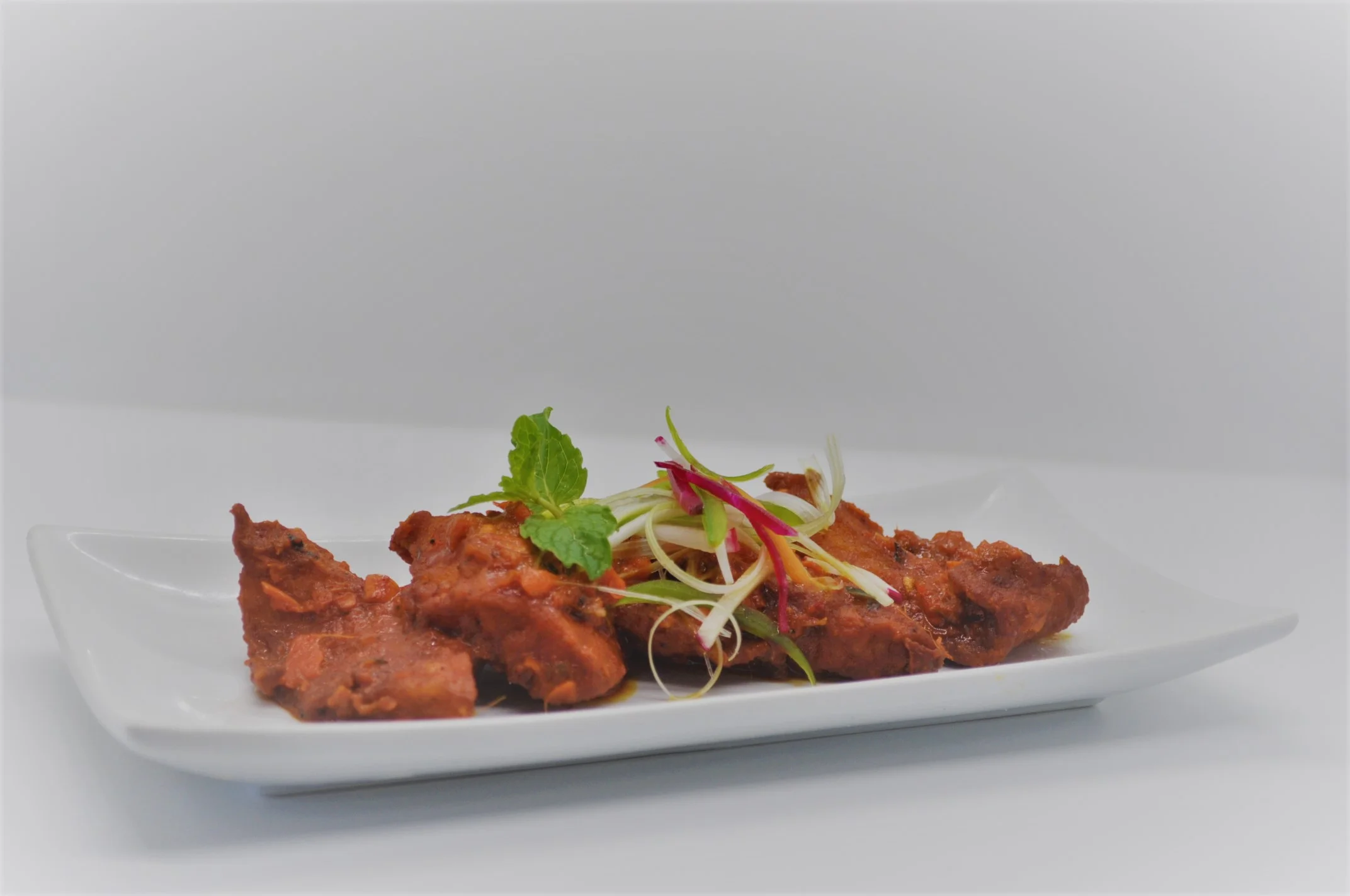 Crispy Indian chicken pakoras garnished with herbs